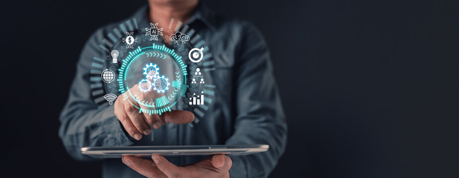 Businessman using tablet with virtual gear interface for business automation. Concept of digital transformation, AI technology, cloud data, finance strategy, and process management.