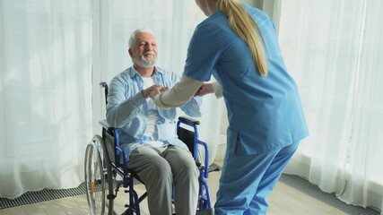 Rehabilitation healthcare. Physiotherapist nurse helps old man patient in wheelchair stand up walking. Man in chair for people with disability doing few steps with nurse helping. Medical caregiver - Powered by Adobe