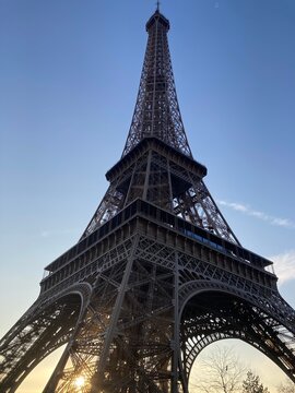 Eiffelturm aus der N&auml;he im warmen Abendlicht mit Sonne hinter der Stahlkonstruktion in Paris