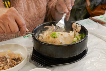 Steaming Samgyetang Ginseng Chicken Soup in Black Bowl