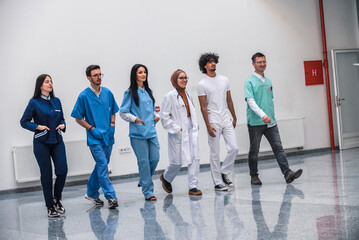Diverse medical team consisting of a doctor nurses walking together in a hospital hallway. This image is suitable for healthcare medicine and medical concepts.