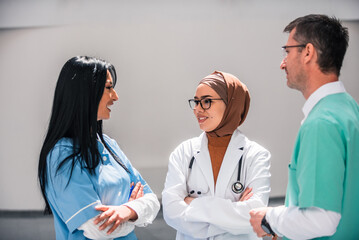 A diverse medical team collaborates discussing patient care in a hospital. The healthcare professionals dressed in uniforms share their expertise and insights to provide the best possible treatment.