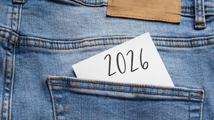 New Beginning: Year 2026 written on a white note sticking out of the back pocket of light blue jeans, symbolizing future plans and resolutions