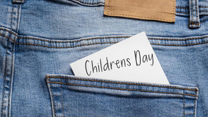 The "Children's Day" card protruding from the back pocket of light blue jeans, symbolizing the celebration and joy of childhood, in natural lighting with a visible leather detail