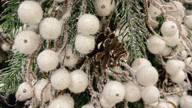 Christmas background with frosted pine needles white glittering berries and a natural pine cone decor
