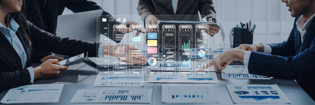 Team of professionals engaged in a business meeting, utilizing digital dashboards for analysis, presenting insights with charts, and planning strategies in a modern office setting. Trope - Powered by Adobe