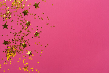 Golden star shape confetti on color background, top view