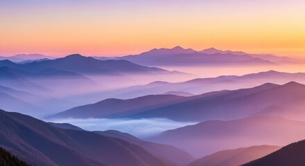 Majestic mountain range at sunrise with layers of fog and vibrant sky