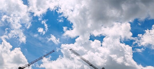 Construction Cranes Against a Cloudy Sky