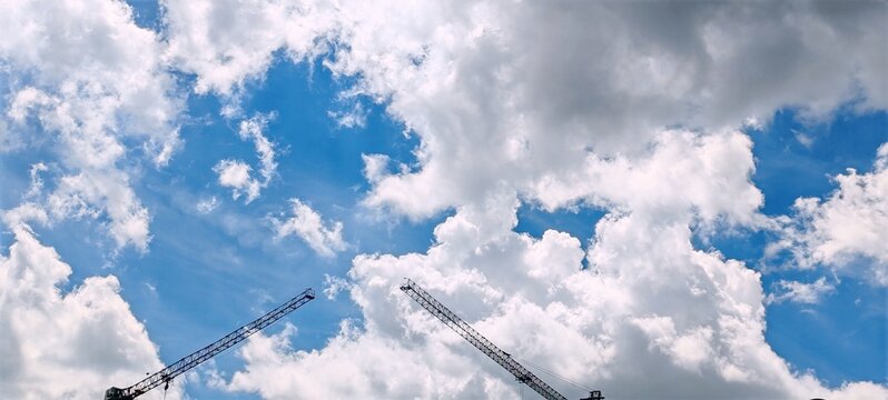 Construction Cranes Against a Cloudy Sky