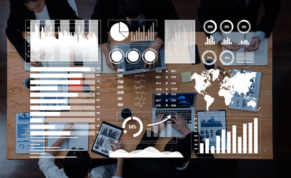 Professionals engage in a collaborative business meeting, analyzing data on laptops, with various charts and graphs displayed, highlighting global trends and insights. Axiom