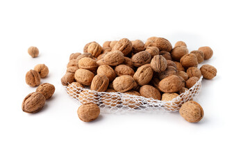Walnuts in shell in opened mesh bag on white background. Studio still life photography. Healthy food and nutrition concept. 
