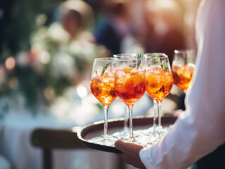 Obraz premium Aperol Spritz auf Serviertablett – stilvolle Sommerdrinks bei Event & Catering