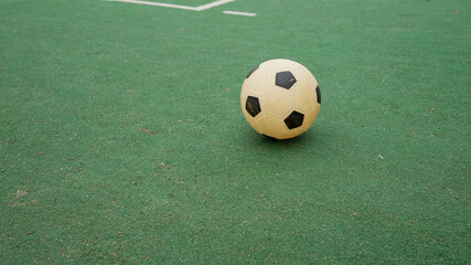 Soccer ball on green field turf with white lines