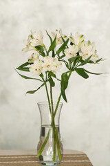 Elegant white alstroemeria flowers in a clear glass vase on a table