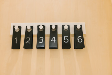 Modern minimalist numbered hooks on beige wall