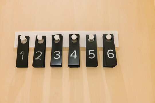 Modern minimalist numbered hooks on beige wall