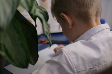 Young boy concentrating on writing homework at desk
