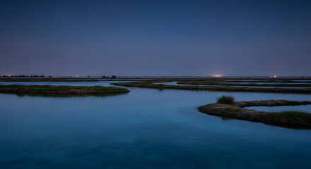 Serene Twilight Over a Tranquil Wetland Landscape with Scattered Islands and Distant Lights