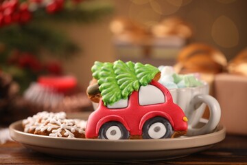 Tasty gingerbread cookies, marshmallows and Christmas decor on wooden table against blurred lights, closeup. Bokeh effect