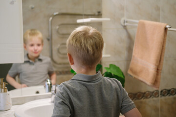 Young boy looking at mirror reflecting on self