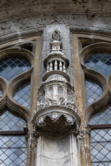 Close up view of an ornate stone canopy carving between arched windows on the facade of Eglise Saint Symphorien in Tours France creating a beautiful historic religious architecture detail