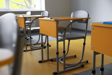 Stylish classroom with desks and chairs at school, closeup
