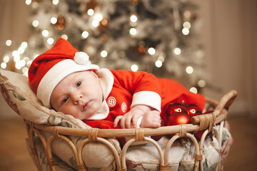 Little girl lays on a holiday background in Santa costume