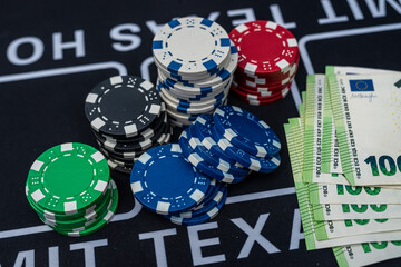 Poker chips and stacks of 100 euro banknotes symbolizing gambling, money and casino winnings