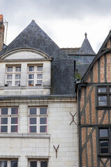 Historic half-timbered house with wooden beams and red brick stands next to a white stone building with slate roof in Tours France creating a beautiful medieval city architecture view outdoors