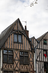 Tall historic half-timbered houses with wooden beams and red brick facades stand on Place Plumereau in Tours France creating a beautiful medieval city architecture landscape view outdoors