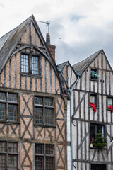 Tall historic half-timbered houses with wooden beams and red brick facades stand on Place Plumereau in Tours France creating a beautiful medieval city architecture landscape view outdoors