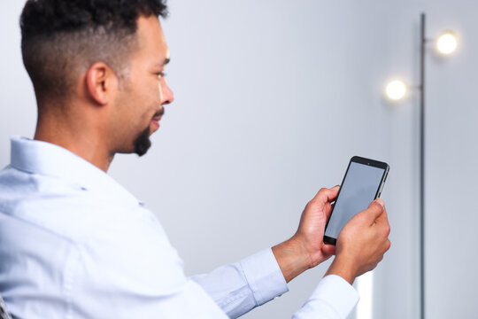 African-american man using modern smartphone in office