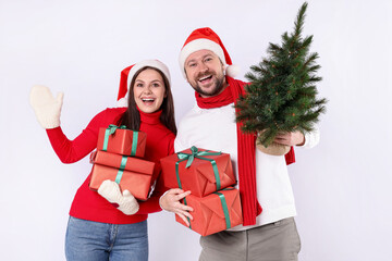 Happy couple with Christmas tree and gifts on white background