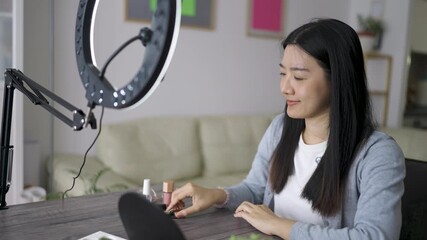 A Thai woman records a makeup vlog at home, speaking confidently to the camera as she demonstrates beauty products and application techniques.