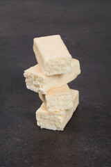 Cottage cheese coconut dessert in white chocolate glaze. Dark gray background. Close-up	