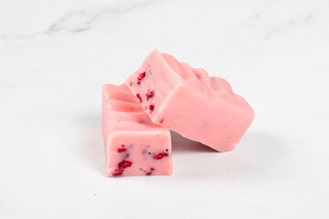 Vegan Raspberry dessert, candy with pieces of freeze-dried raspberries. Close-up	