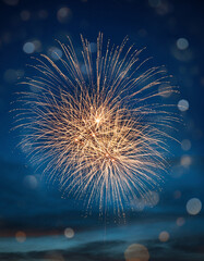 Fototapeta premium Golden Fireworks and Blue Bokeh Lights on Dark Festive Background