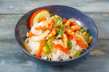 Khao Pad aux crevettes dans un bol bleu, cuisine thaïlandaise, fond bleu rustique