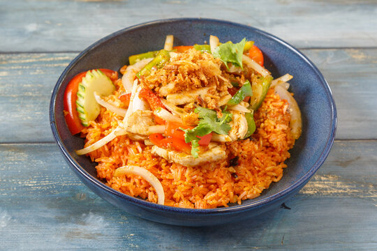 Khao Pad au poulet et basilic dans un bol bleu, cuisine tha&iuml;landaise, fond bleu rustique