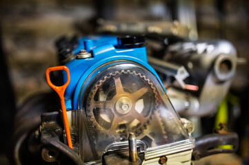 Close-up of a blue-painted Japanese 1.6L SOHC 16-valve internal combustion engine head in a workshop setting. Automotive repair and engineering concept.