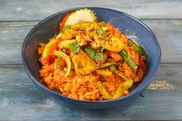 Khao Pad au poulet sel et poivre dans un bol bleu, cuisine thaïlandaise, fond bleu rustique