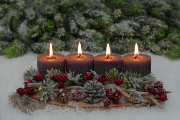 Fourth Advent: Decoration with grey candles, fir branches, cones and berries on a tree slice decorated with space for text in the background.