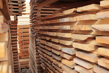 Stacks of planks in the open air. Stacking of pine lumber. Folding edged board. Natural wood.
