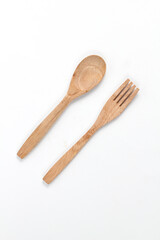 Spoons and forks made of teak wood isolated on white background. Traditional cutlery with a rustic feel