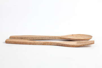 Spoons and forks made of teak wood isolated on white background. Traditional cutlery with a rustic feel