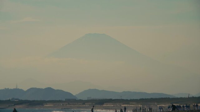 Distant sunset view of Mount Fuji with long lens from Chigasaki, Japan