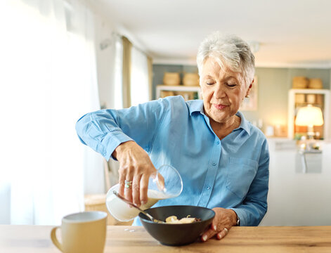 Portrait of a happy mature senior woman having a breakfast at home - Powered by Adobe