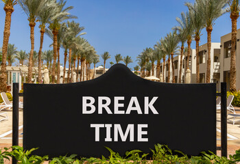 Break time symbol. Concept word Break time on beautiful black road sign. Beautiful palm trees and blue sky background. Business break time concept. Copy space.