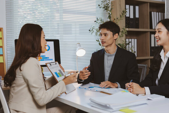 Young business professionals analyzing charts and graphs, collaborating on financial strategy, and planning for company growth